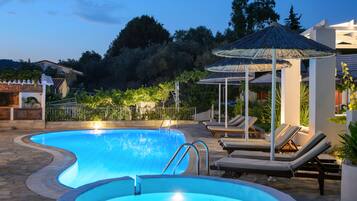 Een buitenzwembad en ligstoelen