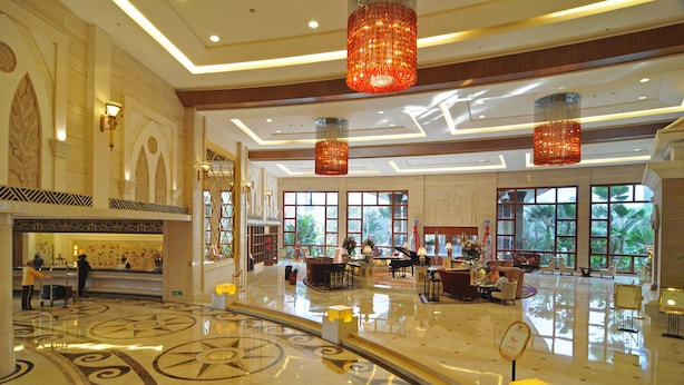 A spacious lobby with a polished marble floor, large windows, and elegant chandeliers. - Conifer Garden Hotel (Haikou)