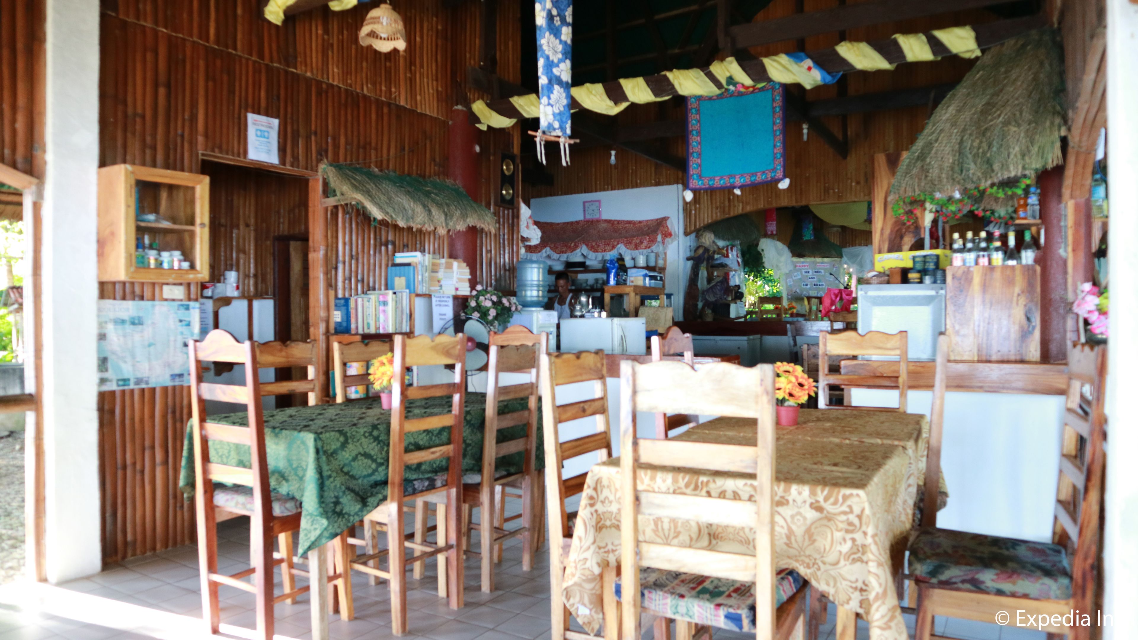A rustic wooden interior with a dining area, a kitchen, and a bar.