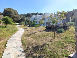 Un sendero de piedra que conduce a un edificio blanco de fachada de piedra.