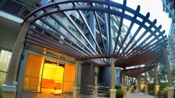 Entrada de um edifício moderno com galeria coberta e uma loja visível chamada "Cluster B".