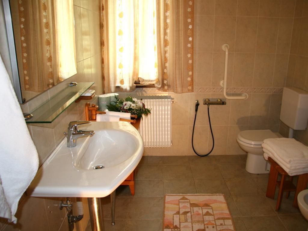 Un baño con lavamanos, inodoro y ducha.