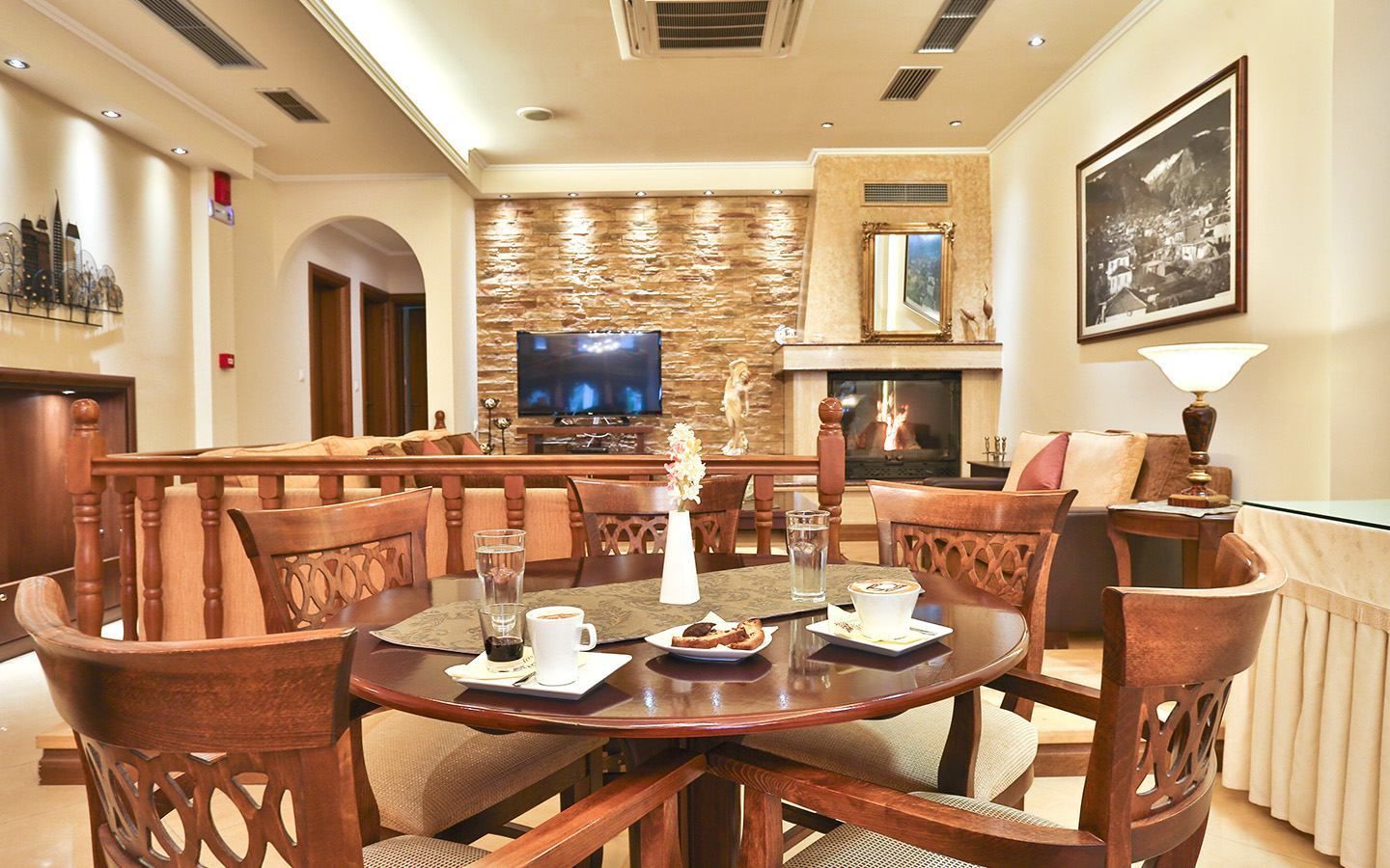 A dining area with a stone wall, a fireplace, and a television.