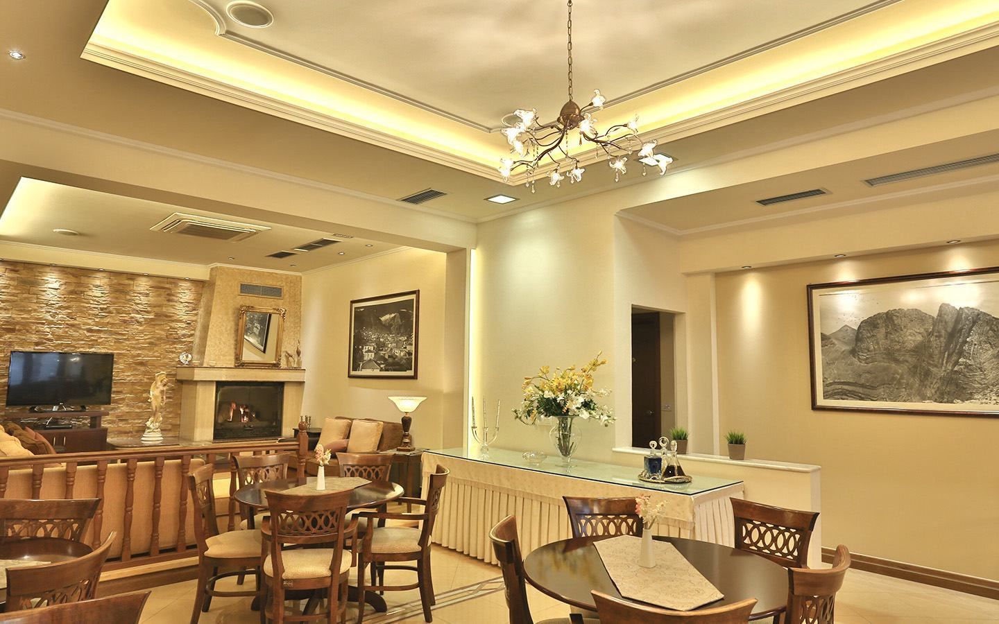 A spacious living area with a fireplace, a television, and a dining table with chairs.