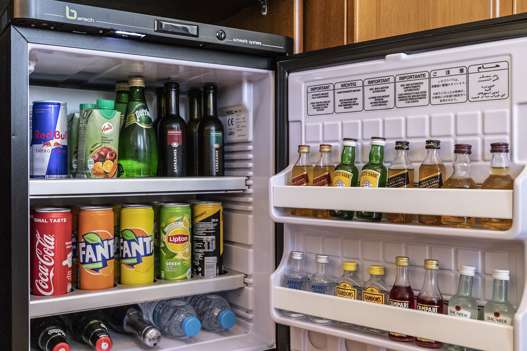 A refrigerator stocked with various beverages including energy drinks, sodas, and alcoholic drinks.