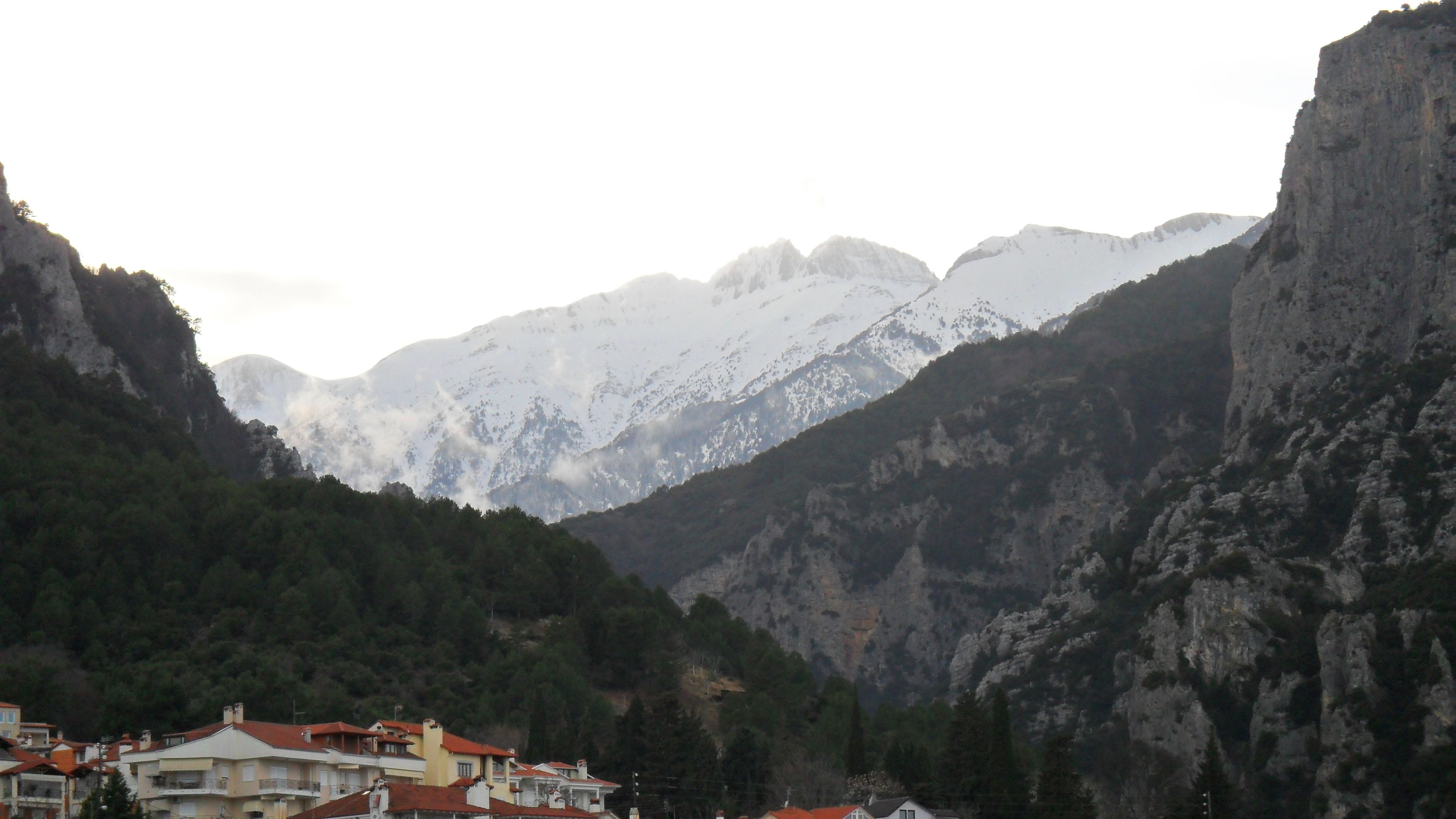 A mountainous landscape with a village nestled in a valley.