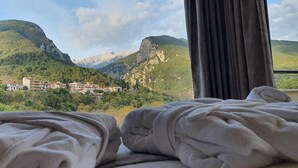 A hotel room with a bed and a view of a mountainous landscape. - Xenios Dias Boutique Hotel (Dio-Olympos)