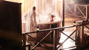 Un área de spa de madera con un jacuzzi y una terraza de madera.