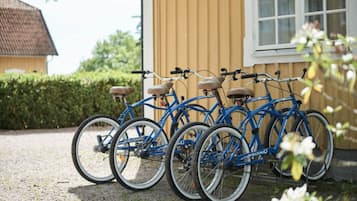 A row of blue bicycles parked outside a building with a yellow exterior.
