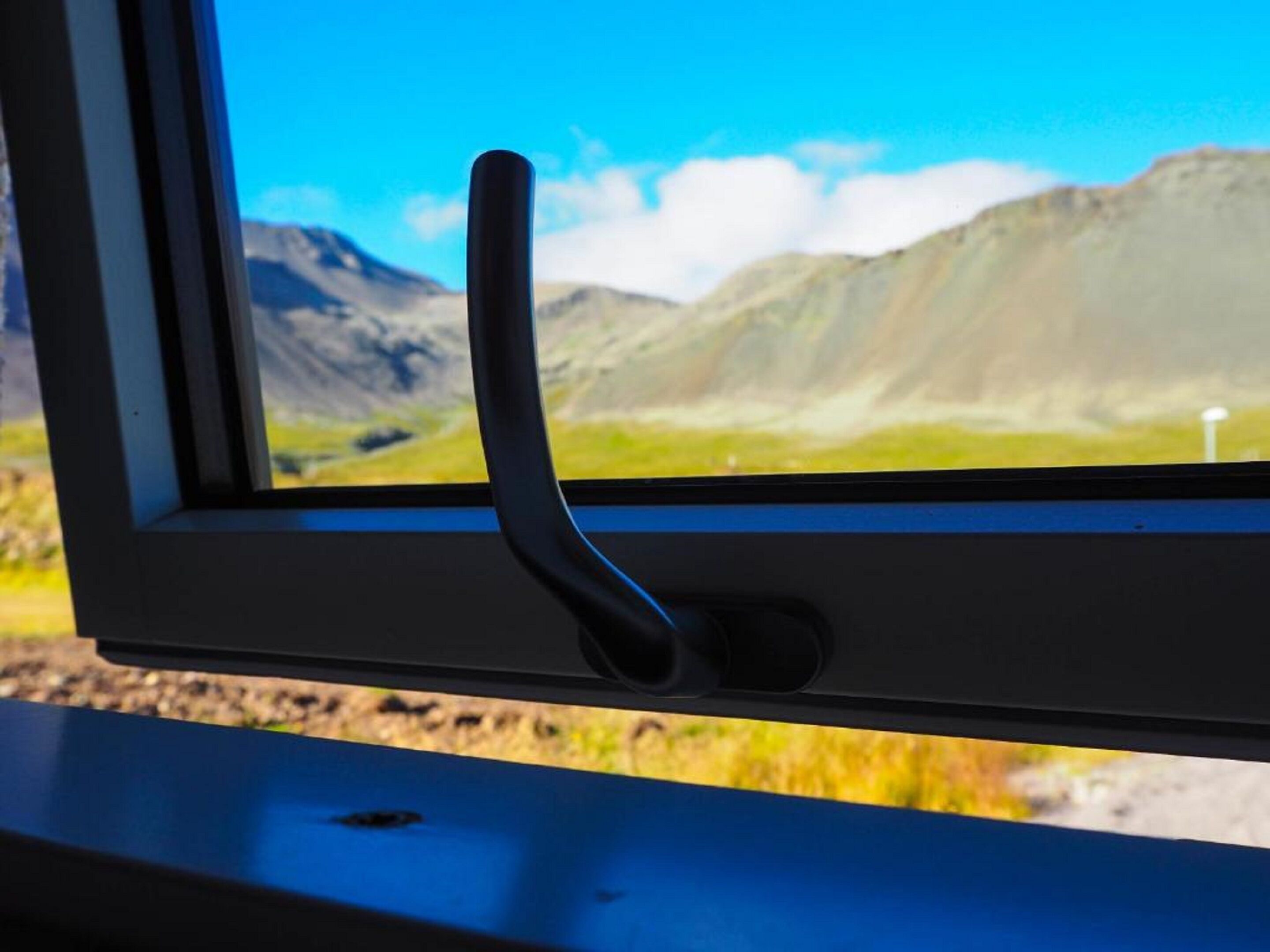 A window with a view of a mountainous landscape.
