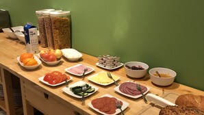 Un bufé de desayuno con diversas opciones de alimentos y acompañamientos.