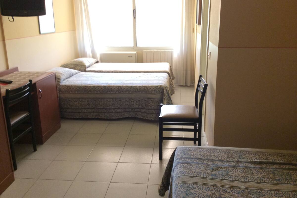 Een kamer met twee bedden, een bureau en een stoel.