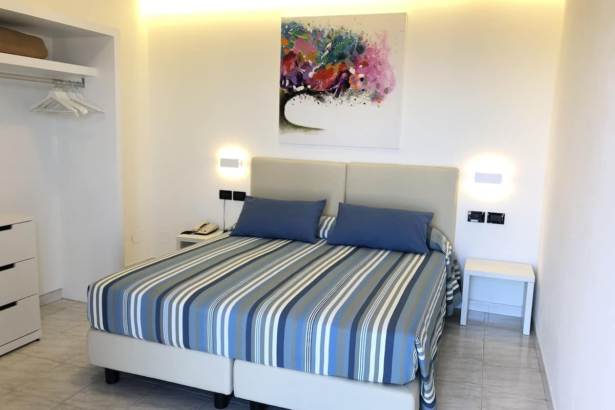 Habitación doble, balcón, vista al mar | Minibar, caja de seguridad en la habitación, escritorio y cunas
