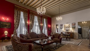 Amplia sala de estar con un amplio sofá, una mesa de comedor y un candelabro.
