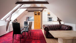 A loft-style room with a dining area, a leather sofa, and a kitchen. - Palads Hotel (Viborg)