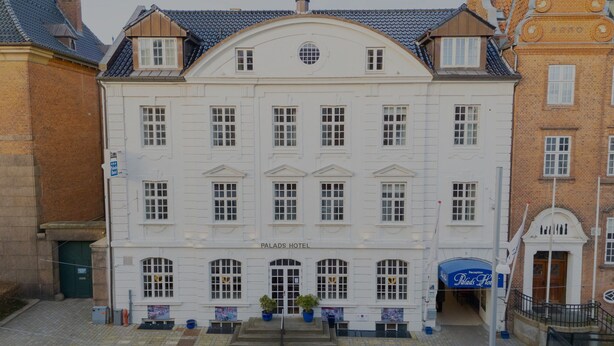 A white building with the sign "Palads Hotel" at the entrance. - Palads Hotel (Viborg)