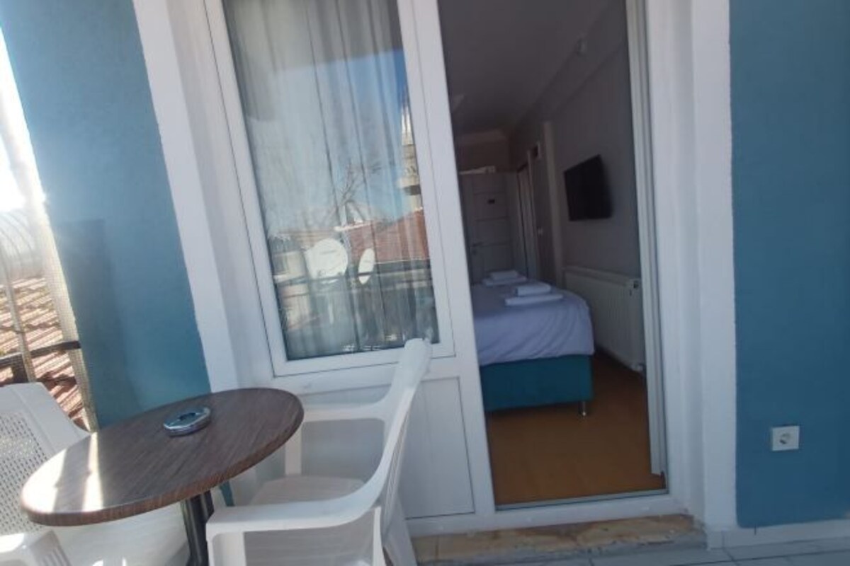 A room with a bed, a small table, and a chair.