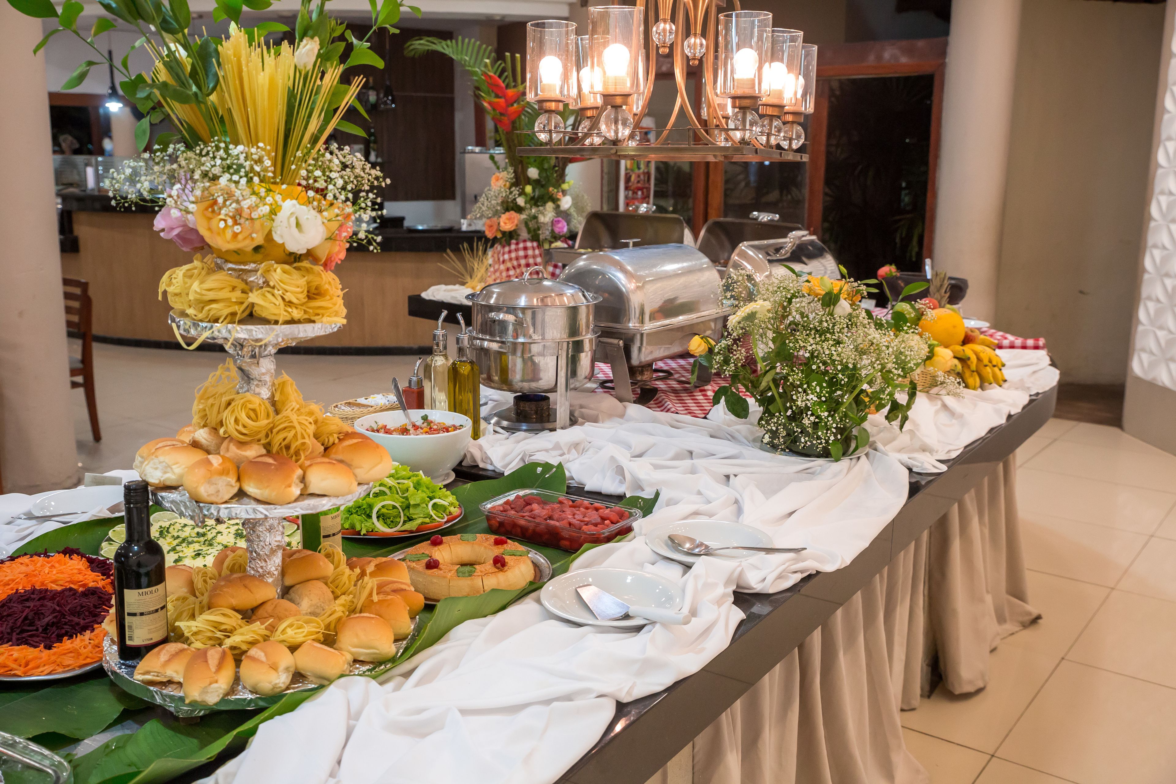 A buffet table with various food items and a wine bottle.