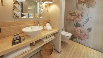 A modern bathroom with a wooden vanity, a white sink, a mirror with geometric patterns, a wall-mounted lamp, and a floral mural.