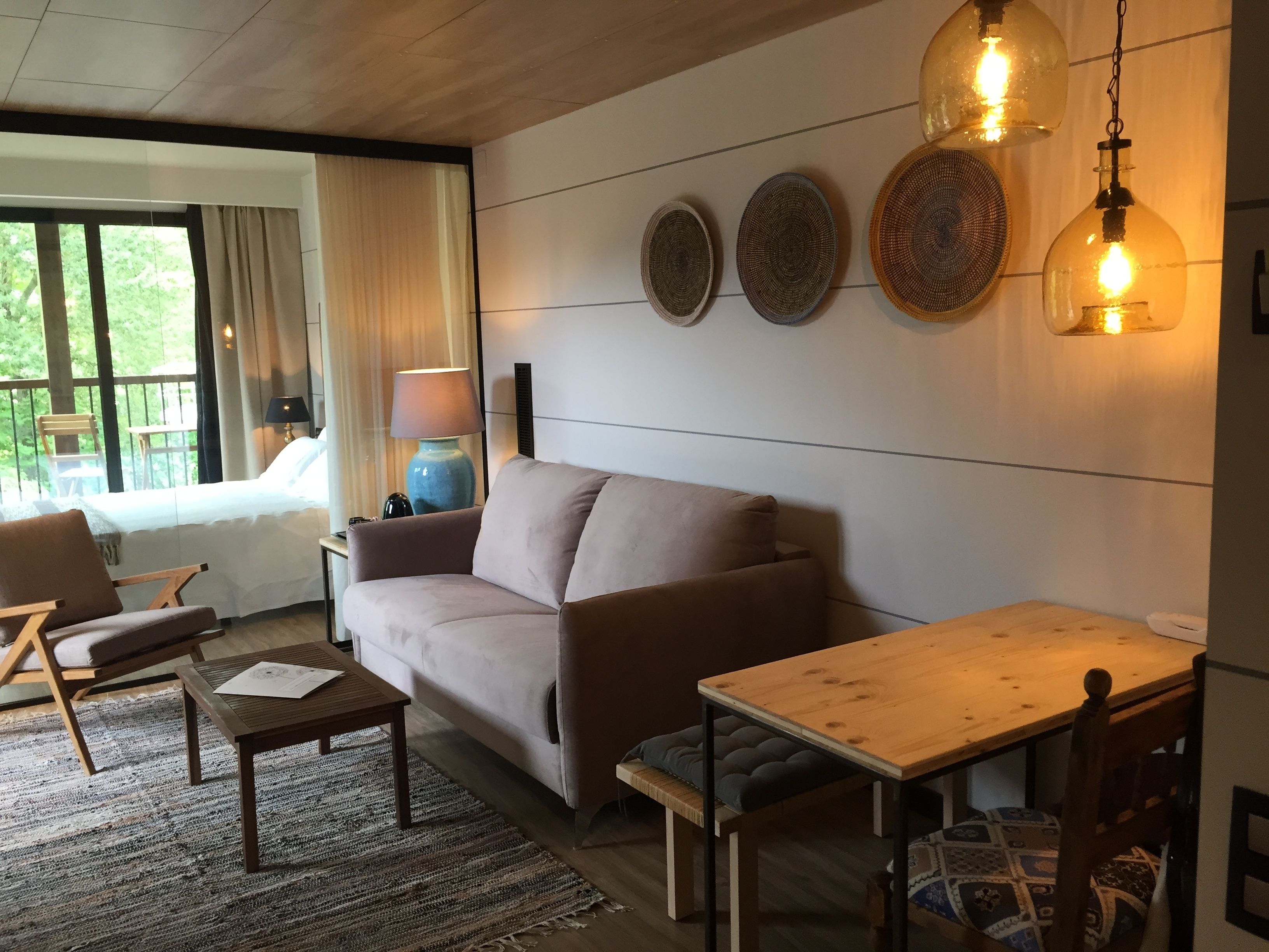 Un salon confortable avec un canapé, une table en bois et une lampe.