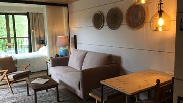 Un salon confortable avec un canapé, une table en bois et une lampe.