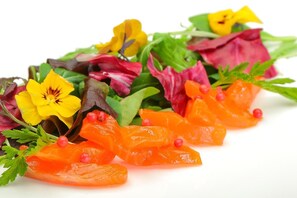 Una ensalada colorida con diversas verduras y flores.