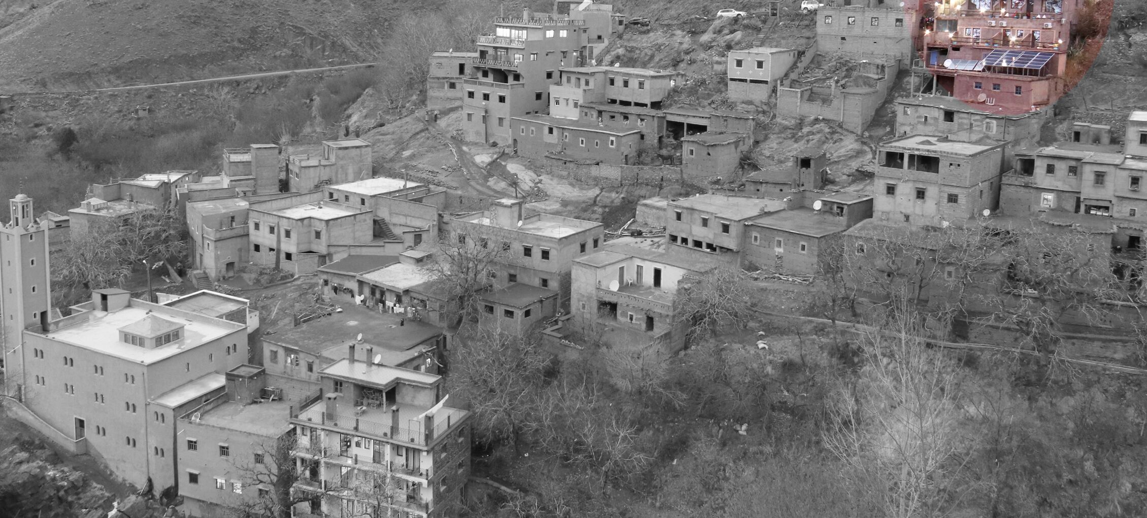 Un asentamiento en una ladera con construcciones muy juntas, algunas con techos planos y antenas parabólicas.