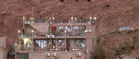 A multi-story building with balconies, air conditioning units, and solar panels.