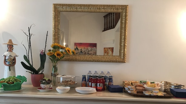 A buffet setup with various food items, beverages, and decorative elements like plants and figurines. - VillaGiò B&B (Frascati)