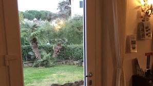 A door with a window, a curtain, and a wall-mounted light fixture. - VillaGiò B&B (Frascati)