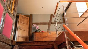 A wooden staircase with a metal handrail leading to a landing.