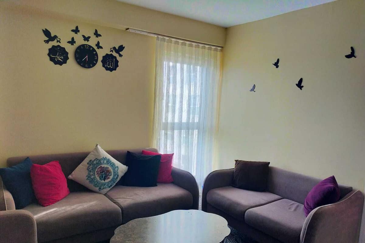 A living room with two sofas, a coffee table, and decorative wall art.