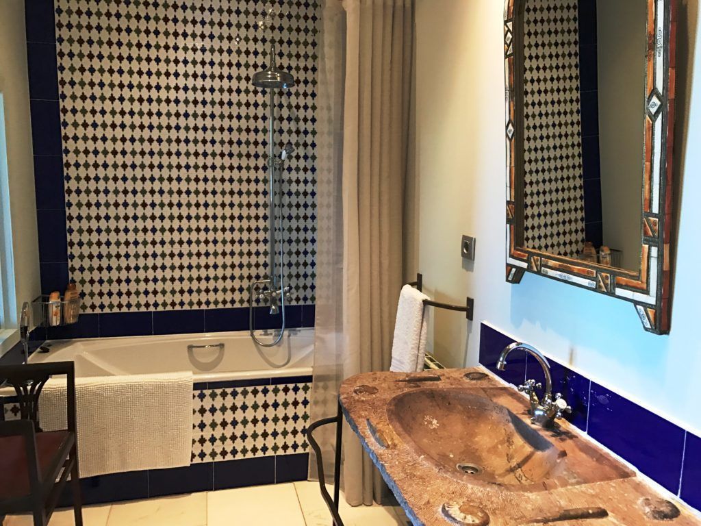 Un baño con bañera, lavamanos de madera y ducha.