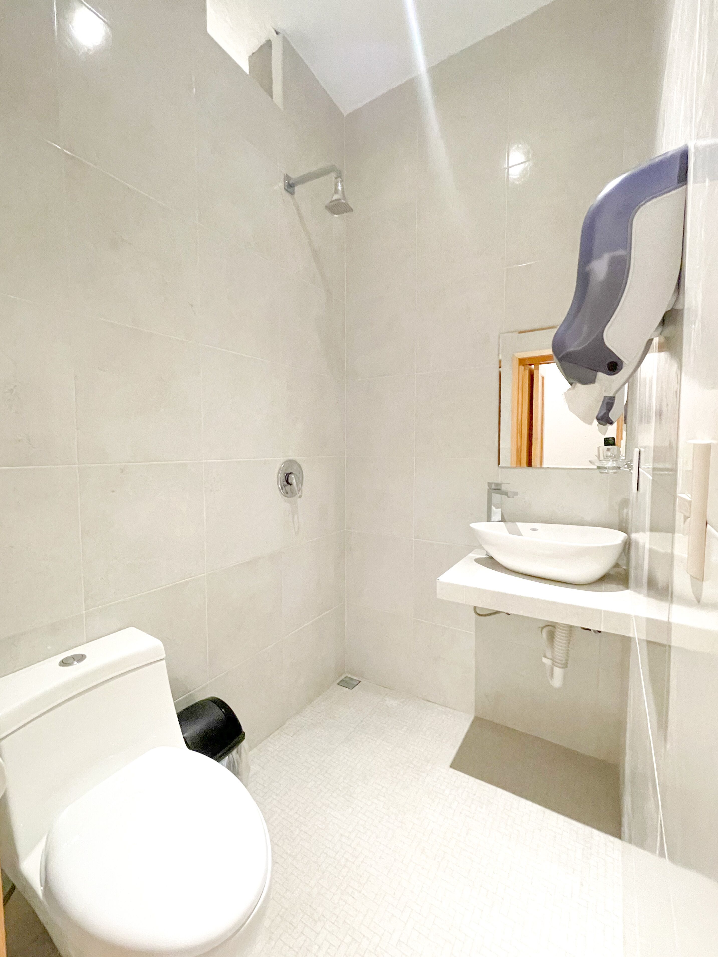 A modern bathroom with a toilet, shower, and sink.