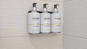 Três frascos modernos da Lather, estilo farmácia antiga, em uma prateleira.
