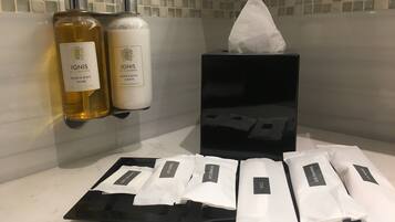 A bathroom with toiletries including hand and body wash, lotion, and a shower kit.