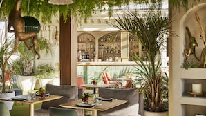 Un restaurante con asientos dentro, una zona de bar y vistas a la ciudad.