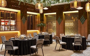 A restaurant with round tables, chairs, and hanging light fixtures. - Hyatt Centric Gran Via Madrid (Madrid)