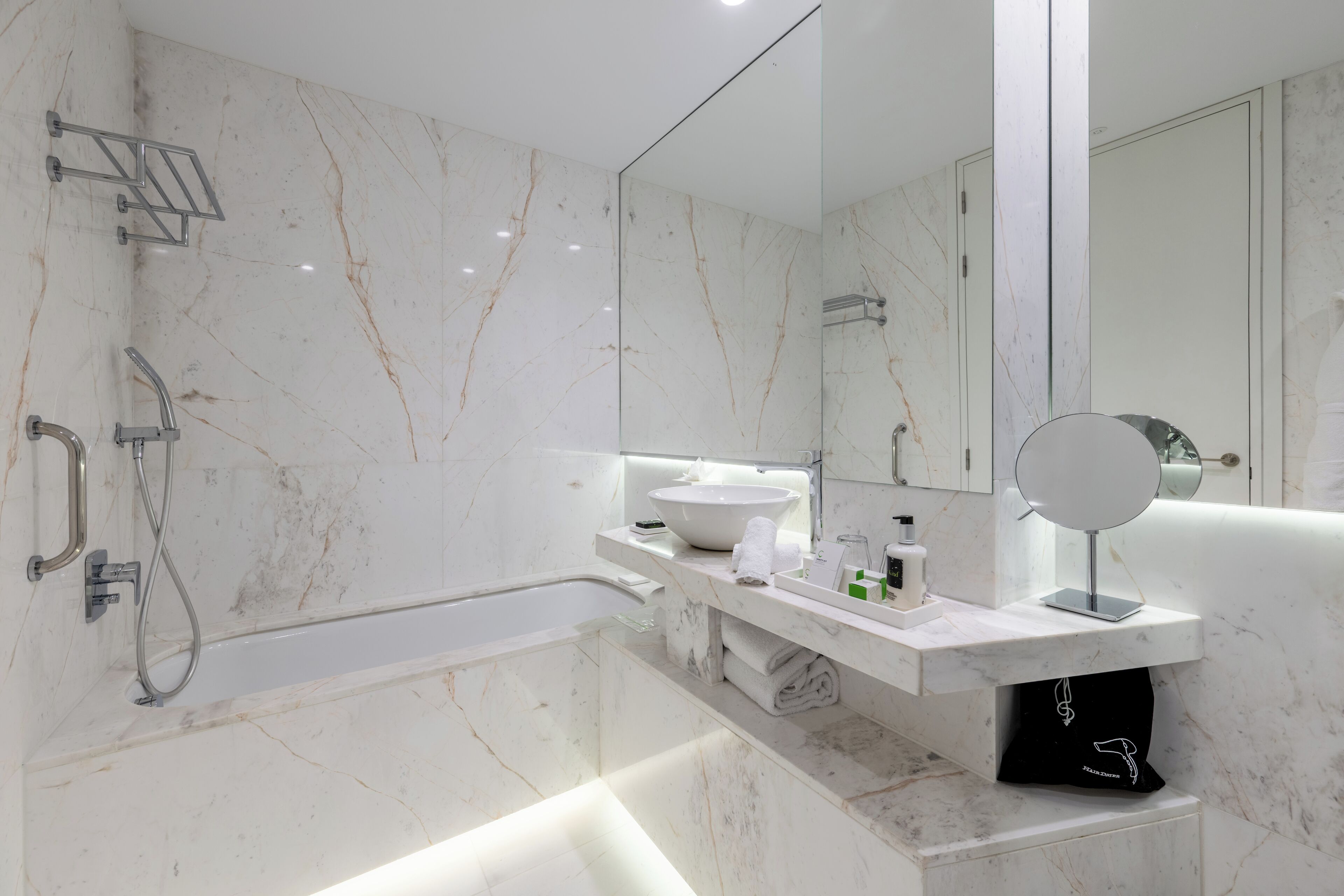 Un baño moderno con bañera, lavabo y espejo.