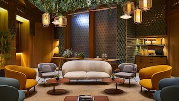 Un interior moderno con sofá, sillones, una mesa de centro e iluminación colgante.