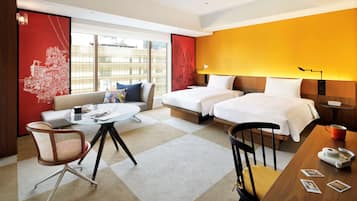 Habitación de hotel con dos camas, un sofá, una mesa de comedor y una silla.