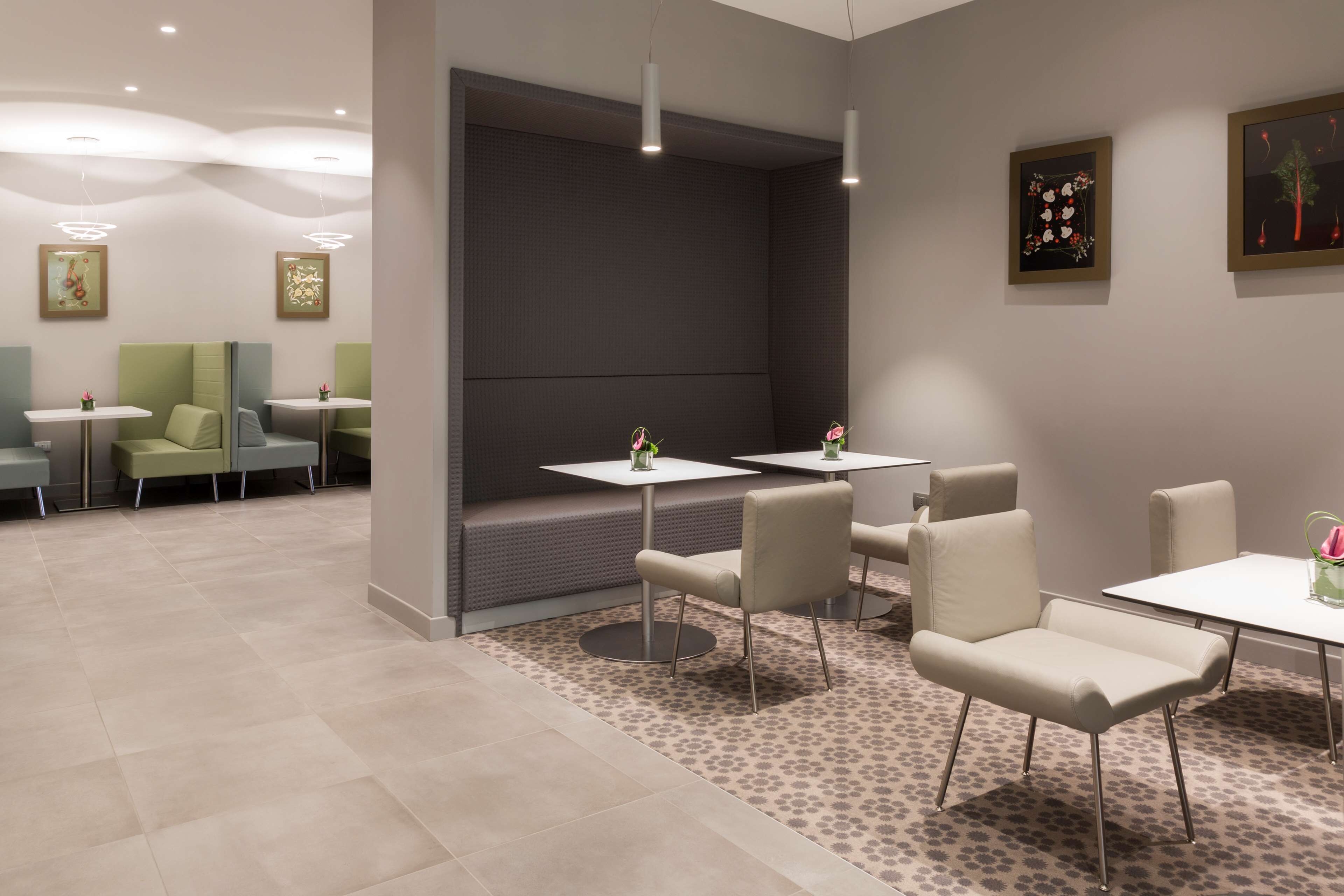 A modern interior with a seating area, tables, and artwork on the walls.