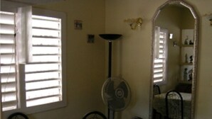 Un coin repas comprenant une table, des chaises, un ventilateur de plafond et un grand miroir mural.