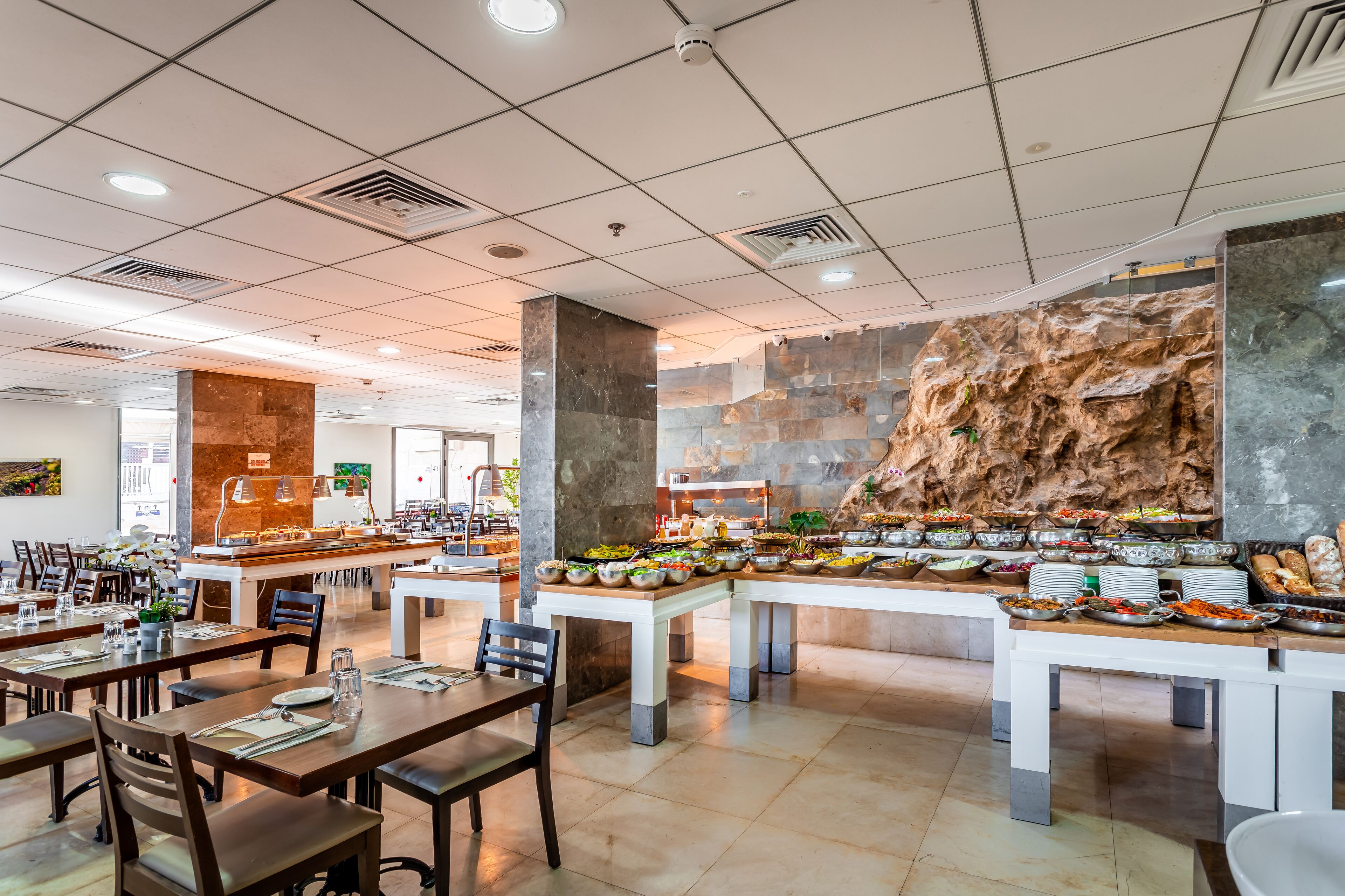 Un restaurant proposant un buffet avec de nombreuses tables et une grande variété de plats.