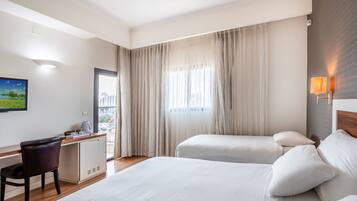 Habitación triple estándar | Minibar, caja de seguridad en la habitación y escritorio