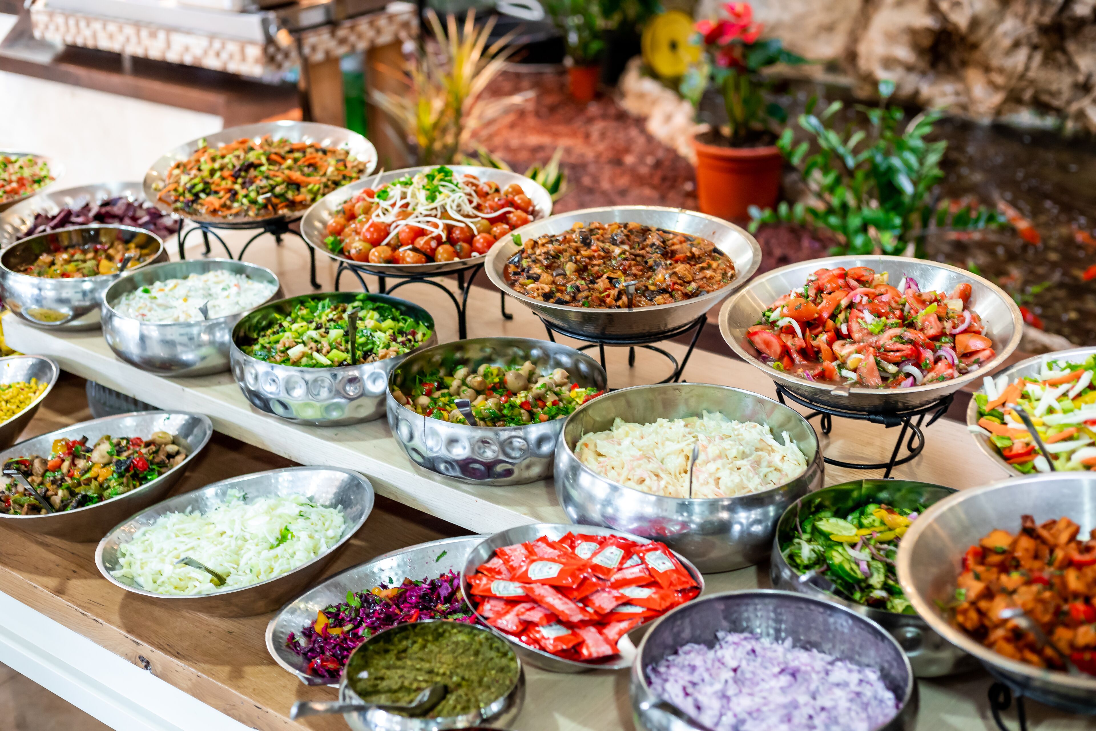 A buffet with various dishes including salads, rice, and other foods.