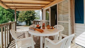 A covered outdoor seating area with a table set for two, surrounded by white chairs. - Vvf Villages Argol (Argol)