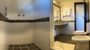 A bathroom with a shower, toilet, and sink.