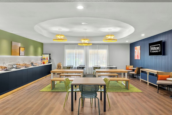 A modern hotel room with a kitchen area, dining space, and seating area. - Spark by Hilton Missouri City (Missouri City)
