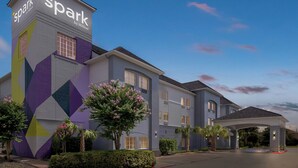A hotel with a modern design, featuring a prominent tower with signage, a covered entrance, and well-maintained landscaping. - Spark by Hilton Missouri City (Missouri City)